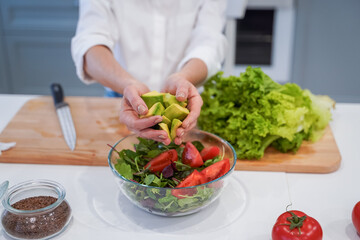 Cooking concept. Woman hands making healthy dinner, cutting vegetables on chopping board, kitchen interior, closeup