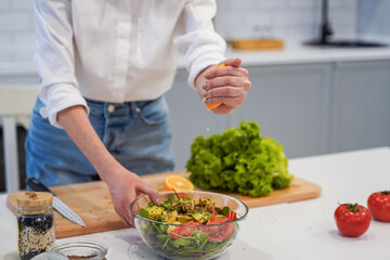 Cooking concept. Woman hands making healthy dinner, cutting vegetables on chopping board, kitchen interior, closeup