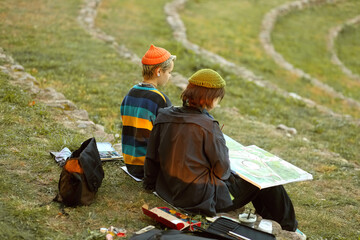 two young and innovative female artists conducting an outdoor painting lesson. Surrounded by...