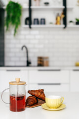 Morning tea and croissants served in a modern kitchen with a stylish design and bright atmosphere