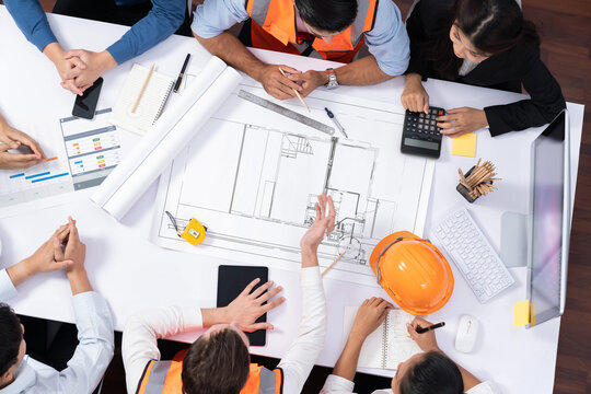 Top view banner of diverse group of civil engineer and client working together on architectural project, reviewing construction plan and building blueprint at meeting table. Prudent - Powered by Adobe