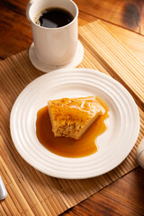 flan dessert, easy homemade recipe also known as creme caramel, caramel custard pudding or egg custard, served on white plate on wooden table.