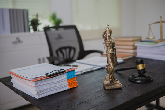 An Asian male lawyer meticulously reviews legal documents, ensuring accuracy and compliance for an upcoming court case. He highlights key points and prepares strategies to effectively
