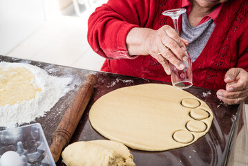 abuela alegre, amasando galletas con la ayuda de sus nietas 