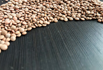 Brown Lentils on dark wooden background