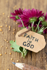 Faith in God, handwritten quote with mustard seeds and flower on wooden table. Close-up. Christian...