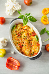 cauliflower baked with sweet pepper and vegetables under cheese