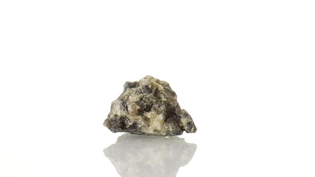 Cordierite mineral stone spinning in a circle on a white background