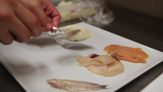 Plating Of A Raw And Cooked Fish Based Appetizer In A Luxury Italian Kitchen