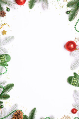 Bright Christmas and New Year frame made with fir tree branches and shining colorful decorations on white background with copy space for your design.