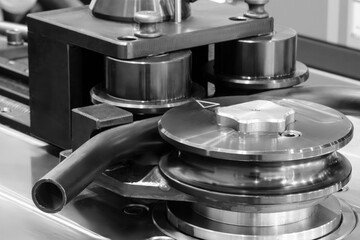 A metal bending machine with a black and silver color is being used