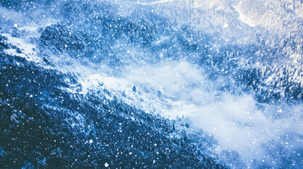 Birds-eye view of a snowy mountain range blanketed in untouched snow during a snowstorm