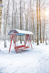 Empty swing in winter time with snow