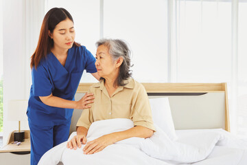 Female doctor nurse take care elderly female patient who is being treated for discomfort due congenital disease gently supporting her shoulder to help her sleep : Elderly health insurance.