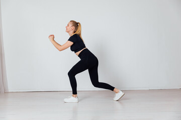 Beautiful blonde woman doing fitness sport gymnastics in a white gym