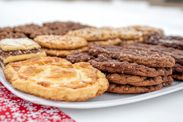 A white plate with a variety of cookies and brownies