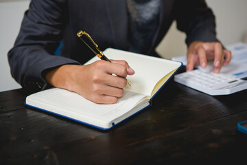 An Asian man works late at his desk papers, determined to meet his deadlines.