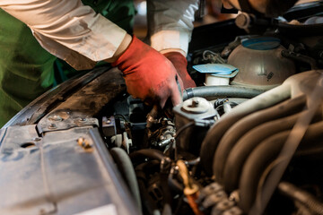 A Mechanic Diagnosing a Car Engine in a Workshop