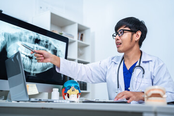 Dentist explaining tooth X-Rays to patient or consultation and recommend guidelines for orthodontics Dentist giving advice on patient's condition. A doctor is diagnose for mouth injury or pain result