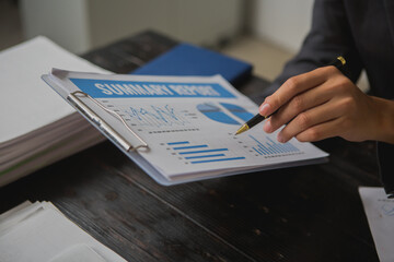An Asian man works late at his desk papers, determined to meet his deadlines.