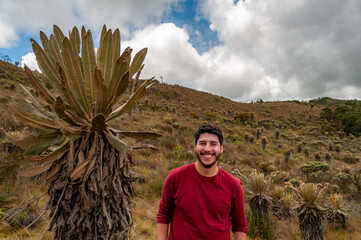 happy young man enjoying joy in the mountain doing backpacking or hiking in nature with red jacket...