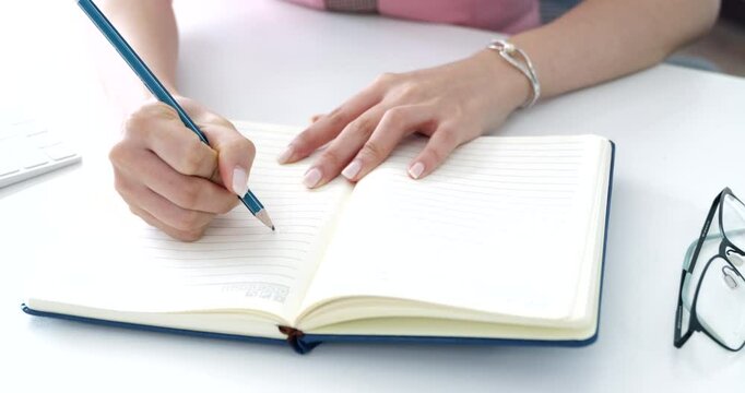Close-up of a woman&rsquo;s hand writing her daily to-do list in a book. Ideal for content on productivity, organization, lifestyle, and self-management, task prioritization and effective work habits