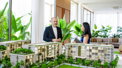 A real estate manager in the office shows the layout of the apartment and advises the client on...