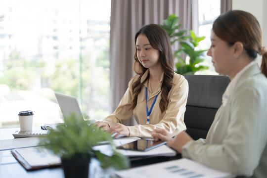 Asian office employee supervising Mentor training intern at office
