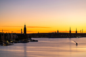 Stockholm, Sweden A boat in the early morning and a skyline silhouette of the city with the City...