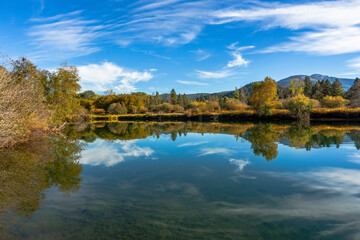 Beautiful mirror reflection of the fall colors trees in calm water. Location is Wolf Creek, Idaho