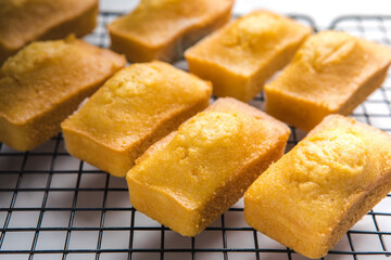 Close-up of corn muffins on plate with bowl of corn meal and additional muffins in the background.