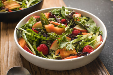 Tasty salad with apple, papaya, lettuce, top view.  Vegetable salad.