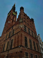 ancient red brick church tower with a clock on the wall