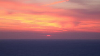 Naklejka premium A stunning sunrise over the ocean, illuminating the sky with vibrant hues of orange, pink, and purple, clouds, sky