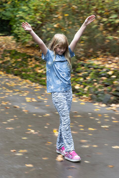 Girl (8-9 years old) on 'Heely's' wheeled shoes skating down hill
