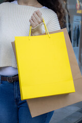 Girl holding shopping bags in front of a clothing store