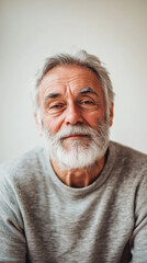 Obraz premium Portrait of a Content Elderly Man with White Beard, Close-up of an elderly man with a gentle smile and white beard, wearing a cozy sweater, radiating warmth and wisdom.