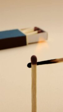 Match lights another and it burns, box of matches in background