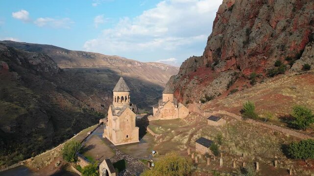 Aerial panning right view Noravank monastery complex, 13th-century Armenian monastery. Holy Mother of God church.Noravank at Amaghu. Red cliffs gorge by Arani village. Tourist destination in Armenia