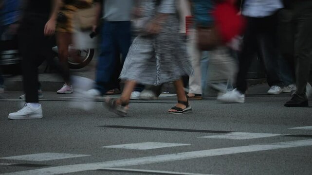 People crowd in the city, Side view pedestrians walking crowd of people crossing road, TimeLapse. Detail of legs crossing a street in the city of Barcelona with traffic of background.