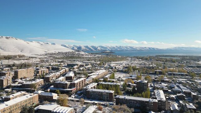 Aerial panoramic fly over view Sevan town and Lake Sevan. Famous Sevan lake - large, high-altitude lake in eastern Armenia. Winter travel visit destination Armenia concept.