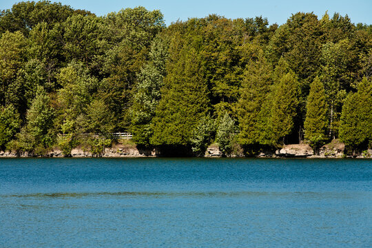 Cedar trees along quarry lake in early autumn  at Harrington Beach State Park, Belgium, Wisconsin