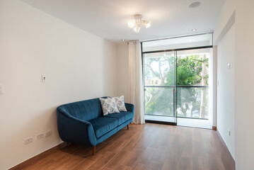 sala de departamento con mampara y vista a la calle , amoblado acabados modernos, piso de madera  y paredes blancas 