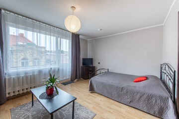 Modern Home Living Room and Windows, Balcony. Luxurious Stylish Modern Apartment. Open Space Interior, Stylish Bed, Scandinavian Design. Hardwood Floor, Old Retro Door.