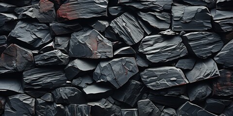 A close-up of a dark and textured stone wall, showcasing the intricate layers and fissures of the natural rock formation.