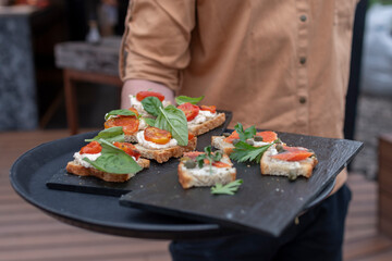 Bruschettas con queso tomate y albahaca en bandeja