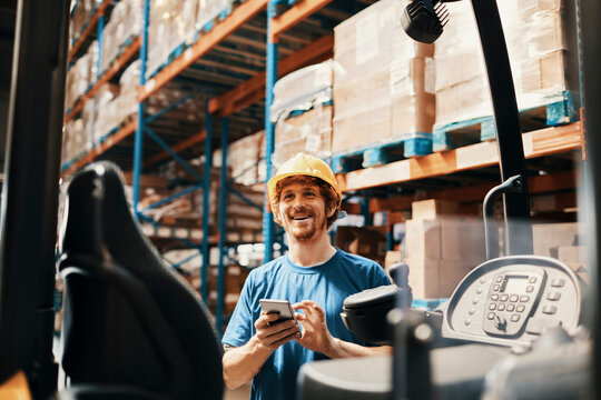 Warehouse forklift driver using smartphone during work