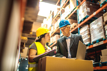 Warehouse worker discussing logistics with manager over a laptop