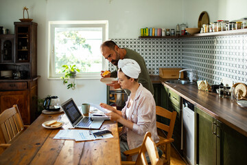 Couple reviewing bills and finances together at kitchen table