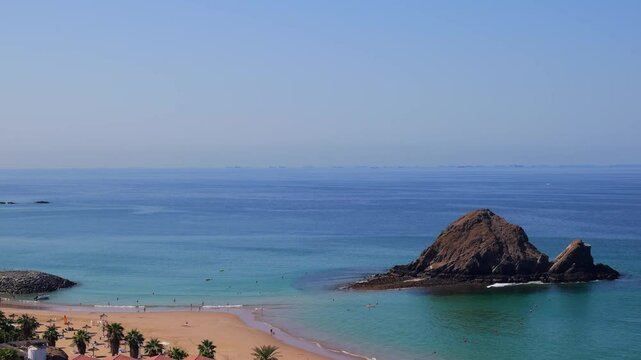 Snoopy Island in Fujairah, UAE. Aerial view of the beach with turquoise waters, a rocky island and a resort nearby